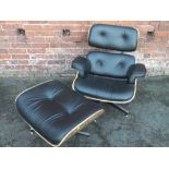 AN EAMES STYLE LOUNGER CHAIR AND STOOL, upholstered in black, on bentwood frame, raised on chrome