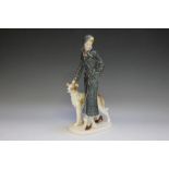 A GERMAN ART DECO STYLE PORCELAIN FIGURINE OF A LADY WITH BORZOI DOG, impressed and painted marks to