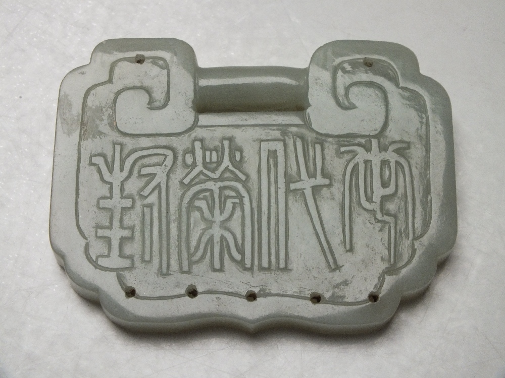 A LARGE CHINESE CELADON JADE BUCKLE / PENDANT, finely carved in shallow relief with bird and foliate