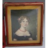 A 19TH CENTURY PORTRAIT MINIATURE OF A YOUNG LADY WITH A RED NECKLACE, with gilt mount, set in a