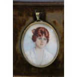 A TWENTIETH CENTURY OVAL PORTRAIT MINIATURE OF A YOUNG LADY WITH RED HAIR IN A WHITE DRESS, in an