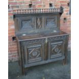 A 19TH CENTURY AND LATER CARVED OAK CUPBOARD, the lower coffer section with half hinged lid,