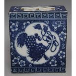 A CHINESE BLUE AND WHITE CERAMIC OPIUM PILLOW, with foo dogs to all sides amongst foliate detail,