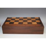 A VICTORIAN MAHOGANY GAMES BOX, with a chequer board to the exterior, the hinged lid opening to