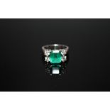 AN 18 CARAT WHITE GOLD EMERALD AND DIAMOND RING, set with an emerald cut emerald measuring approx