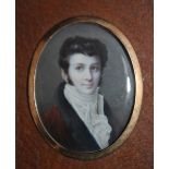 A LATE 19TH / EARLY 20TH CENTURY OVAL PORTRAIT MINIATURE OF A YOUNG GENTLEMAN IN BLUE COAT WITH A