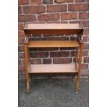 A 1920S OAK BOOK TROUGH, of three stages with shaped supports and original cappings and castors, H