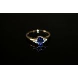 A HALLMARKED 10K GOLD AAA TANZANITE AND DIAMOND RING, the central oval tanzanite being approx 1.65