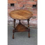 A PROVINCIAL OAK CRICKET TABLE, the typical circular top raised on three turned supports united by