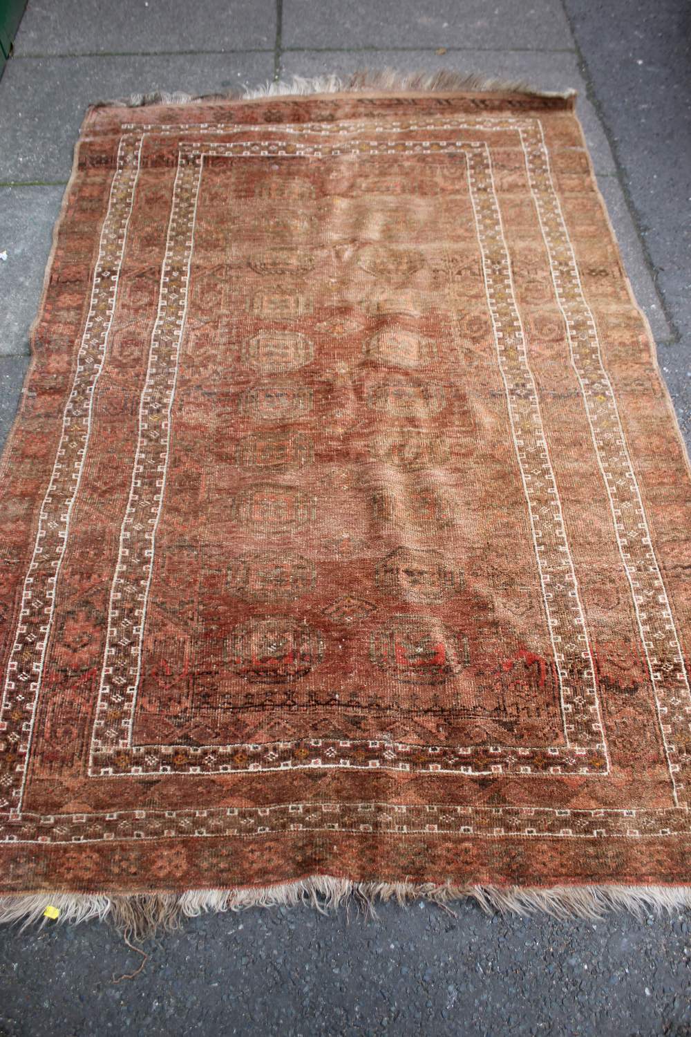 A BOKHARA STYLE WOOLLEN RUG, with an all over pattern on a mainly red ground, 137 x 208 cm - Faded