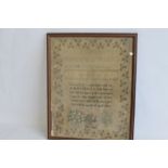 AN ANTIQUE SAMPLER IN A FRAME, religious verse to middle, with peacock and trees below, named "Jane
