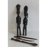 TWO AFRICAN CARVED HARDWOOD FIGURES, a carved wooden spoon with African soldier finial and two othe