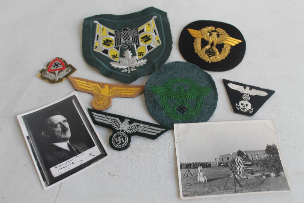 A GROUP OF GERMAN TYPE CLOTH BADGES, together with two photos