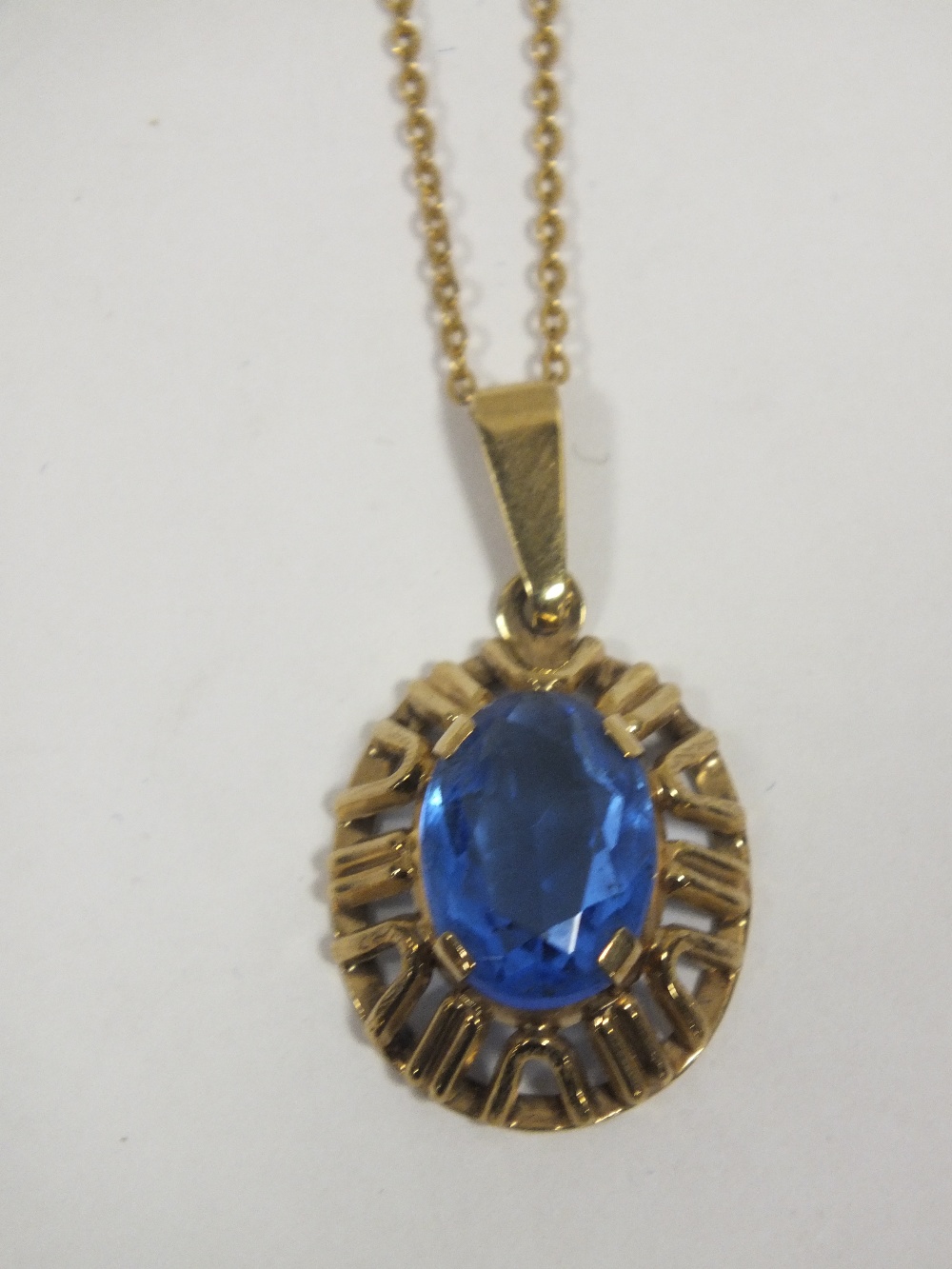 A 9CT GOLD PENDANT ON CHAIN SET WITH LARGE BLUE STONE