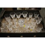 A TRAY OF CUT GLASS DRINKING GLASSES AND A DECANTER