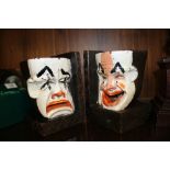 A VINTAGE PAIR OF CARVED TREEN BOOKENDS IN THE FORM OF THEATRICAL HAPPY / SAD MASKS