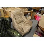 AN UPHOLSTERED WINGBACK ARMCHAIR