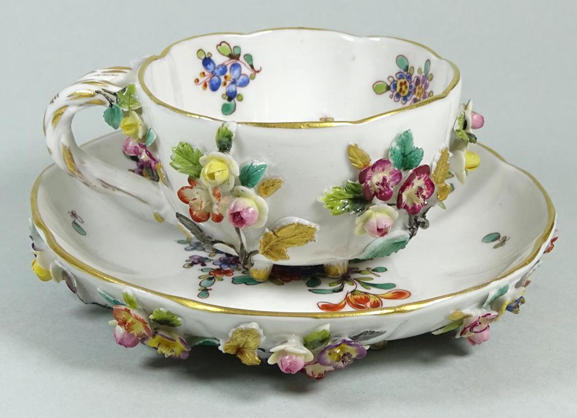 Kl. Tasse mit U.T. "Capodimonte", aufgesetzte Blüten, wohl 19.Jhd., H-4,3 cm, D-U.T. 12 cm,