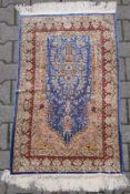 Seiden Kayseri Gebetsteppich mit rosefarbener Micrab vor blauem Grund. 107 x 63 cm, guter Zustand.