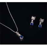 An 18ct white gold, diamond, and sapphire pendant set with a pear-cut sapphire beneath a round