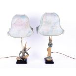 Two late 20th century patinated metalware figural table lamps in the Tibetan style each with gilt