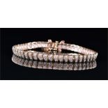 A 9ct yellow and white gold and diamond bracelet the articulated segments each set with a diamond