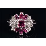 An 18ct white gold, diamond, and ruby cluster ring centred with a square-cut ruby, mounted at either