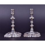 A pair of George V silver taper sticks London 1934, by Garrard & Co, the turned stems with petal