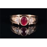 A 9ct yellow gold, diamond, and ruby ring collet set with an oval-cut ruby, the triangular-shaped