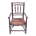 A 19th century oak country stick back armchair with wicker seat and supported on turned legs with