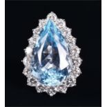 A white gold, diamond, and blue topaz ring set with a large pear-cut light blue topaz of