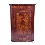A George III mahogany corner cupboard  with single door over single drawer and two dummy drawers,