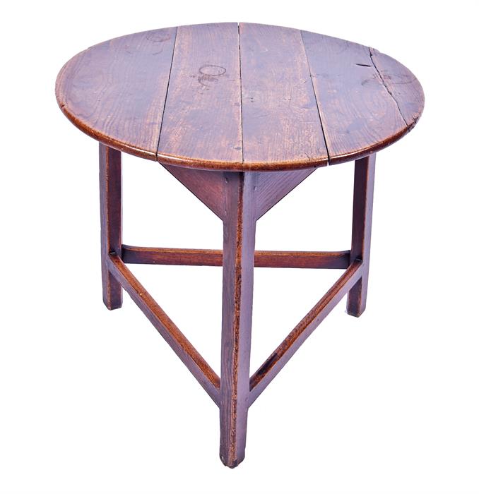 An 18th century or later oak cricket table the circular top on chamfered legs joined by