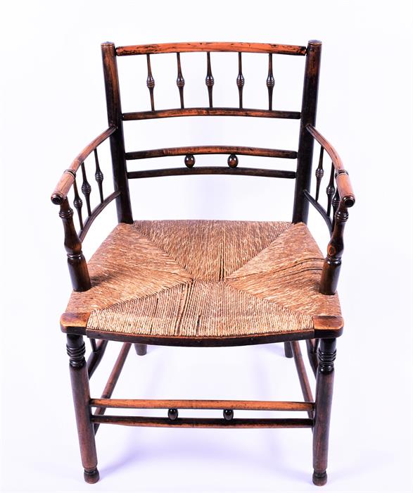 A Victorian oak and stained beech William Morris Sussex chair with rush seat and turned supports,