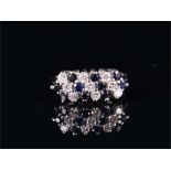 An 18ct white gold, diamond, and sapphire ring set with diagonal rows of round brilliant-cut