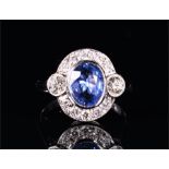 An 18ct white gold, diamond, and sapphire cluster ring set with an oval cut sapphire of