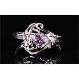 A 9ct white gold and amethyst ring the swirled openwork mount set with a round cut amethyst, size P,