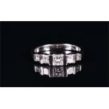 An 18ct white gold and diamond ring bar-set with five graduated princess-cut diamonds, of