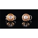 A pair of 18ct yellow and white gold and diamond earrings of circular form, each with a round