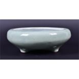 A Chinese stoneware celadon glazed bowl raised on three short feet, 22cm diameter CONDITION REPORT