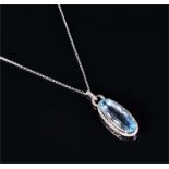 A 9ct white gold, diamond, and blue topaz pendant set with an elongated oval-cut faceted topaz,