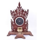 An early 20th century or earlier Eastern brass and carved hardwood shrine gong brass gong set within