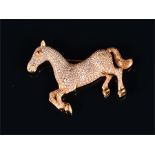 A yellow metal and diamond horse brooch (tests as 18ct gold) the body of the prancing horse pave set