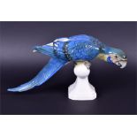 Two Royal Dux porcelain models of birds to include a large blue Macaw perched upon a white stand, 22