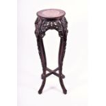 A Chinese carved hardwood jardiniere / plant stand with inset marble top the circular top with