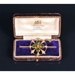 An Edwardian 9ct yellow gold, synthetic peridot, and split seed pearl bar brooch the openwork