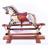 An Edwardian painted rocking horse  fitted with studded leather livery and saddle, fitted on a
