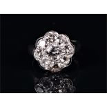 An 18ct white gold and diamond daisy cluster ring set with nine round brilliant-cut diamonds of