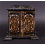 A late Victorian papier mache table-top cabinet with shaped scroll borders, the twin gilt and