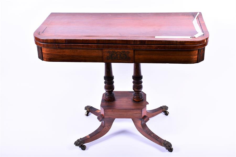 A 19th century rosewood veneered folding card table the top and frieze with brass inlay supported on